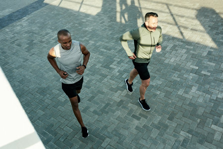 Friends, above or running for city fitness, exercise or workout wellness in social sports with coach. Men, team or personal trainer for athlete marathon, race or competition training accountabilityの写真素材