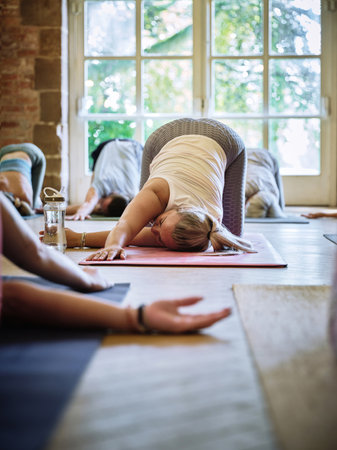 Woman, yoga class or stretching arm for body flexibility or healing in zen studio with energy. Community, relax or group of calm people in pilates with mindfulness, support or wellness for chakraの写真素材