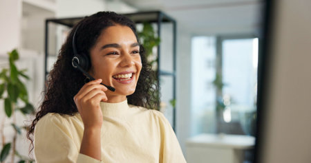 Talking, happy woman and customer service in call center with headset, communication and online consulting. Smile, friendly consultant and sales office for CRM contact support, advice or businessの写真素材