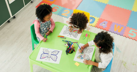Above, education and drawing with friends in classroom for child development, artwork and creative project. Youth, academy and growth with students at school for knowledge, learning and kindergartenの写真素材