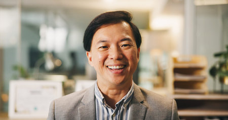 Portrait, business and Asian man laugh in office as insurance agent, risk advisor or claims specialist. Smile, professional and confident employee at work as policy broker or coverage consultantの写真素材