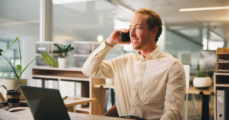 Business, phone call and man in office, smile and communication with financial advice. Laptop, employee and accountant in workplace, cellphone or conversation with schedule for tax review or feedbackの写真素材