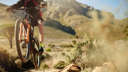 Cycling, off road and ramp with person in mountains for outdoor exercise, fitness or hobby. Bike, jump and trail with athlete or cyclist in nature for challenge, performance or sports trainingの写真素材