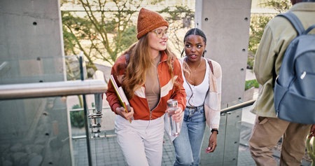 Conversation, education and walking with friends on stairs at college or university campus for learning. Development, growth and study with woman students outdoor at school together for futureの写真素材