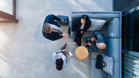 Business people, above or collaboration in airport lounge for meeting or seminar, workshop with layover or delay. Top view, accountant or communication at convention for networking in travel buildingの写真素材