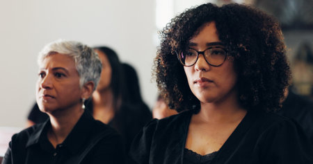 Funeral, faith and women in church, mourning and sadness for loss, memorial service and Christianity. Thinking, catholic and people with depression for grief, ceremony and ritual to honor the deadの写真素材