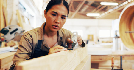 Industry, sanding and woodwork with woman in workshop for manufacturing or production process. Creative, design and lumber with carpenter in studio for carpentry, craftsmanship or manual laborの写真素材