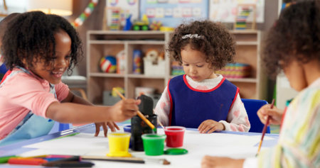 Learning, children and painting in class for art, creative talent and development in preschool. Education, students drawing and kids with watercolor for growth, artwork and sketch on paper with brushの写真素材