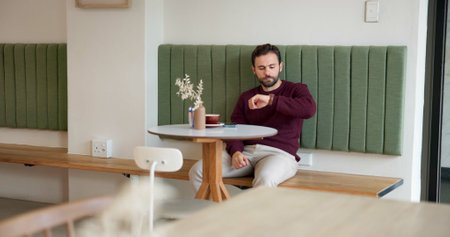 Thinking, waiting and time with man in cafe for customer service, lunch order and date. Hospitality, reflection and late appointment with person in coffee shop for wristwatch, cafeteria or restaurantの写真素材