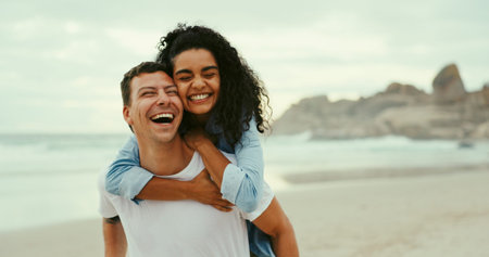 Piggyback, laugh and love with couple at beach for romantic vacation, travel adventure and bonding. Happiness, holiday and partner with man and woman outdoors on date for honeymoon, relax and summerの写真素材