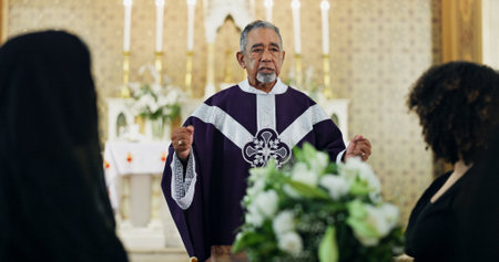 Funeral, preacher and man with prayer in church for farewell service, mourning death or grief. Respect, goodbye or pastor preaching with family in Christian cathedral for burial, talking or memorialの写真素材