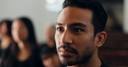 Funeral, loss or man with death in chapel for farewell service, mourning person or goodbye. Face, remember or grieving with sorrow or respect in cathedral for burial, listening and memorial ceremonyの写真素材