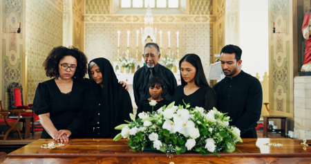 Sad funeral, death or family with coffin in church for farewell service, mourning or grief. Dead, goodbye or grieving with sorrow or respect in Christian cathedral for burial, memorial or ceremonyの写真素材
