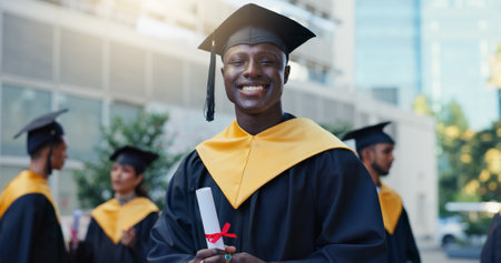 Man, student and graduation with diploma in city, education and pride for achievement at college campus. Person, excited and certificate for learning, scholarship or outdoor in portrait at universityの写真素材