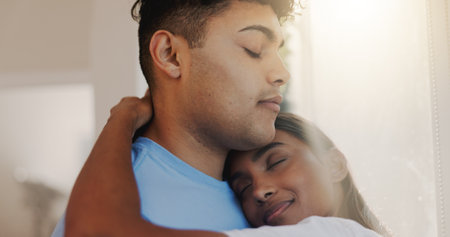 Hug, love and romance with couple in home together for morning affection, bonding or wake up. Safety, trust or weekend with man and woman embracing in apartment for commitment, marriage or securityの写真素材