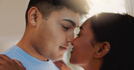 Love, nose and romance with couple in home together for morning affection, bonding or wake up. Safety, security or smile with man and woman in apartment for commitment, marriage or relationshipの写真素材