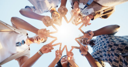 Star hands, circle and group of people with community, collaboration or teamwork for volunteering. Gathering, peace and friends with fingers together for synergy, solidarity or bonding from low angleの写真素材