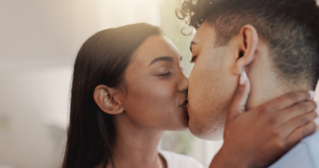 Kiss, love and security with couple in home together for morning affection, bonding or wake up. Romance, safety or trust with man and woman in apartment for commitment, marriage or relationshipの写真素材