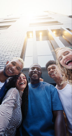 Campus, portrait and student friends in city together for education, learning or scholarship from below. College, buildings or university with happy men and women outdoor for development or growthの写真素材