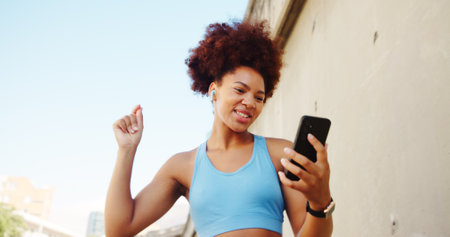 Fitness, dancing and girl on break in city for running, outdoor workout or training motivation. Playlist, earphones and happy runner with music for sports routine, exercise or wellness for healthの写真素材