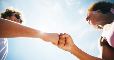 Woman, man and fist bump for fitness, outdoor and low angle with achievement, goals and training...
