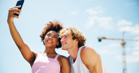 Woman, man and selfie for fitness, city and happy with exercise, break and post on web in summer. People, interracial couple and smile with photography, profile picture and social media for trainingの写真素材
