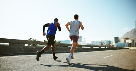 Men, back and running with road in city for workout, exercise or outdoor cardio training. Active,...