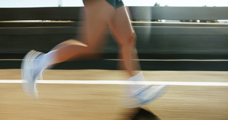 Motion blur, fitness and legs of person running on bridge in city for race, marathon or training....