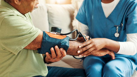 Nurse, hands and blood pressure for senior man on sofa with healthcare assessment for hypertension...