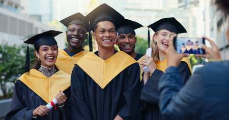 Happy people, students and graduation with camera for picture, memory or scholarship together in city. Group, friends or graduates with smile for academic qualification, photography or capture momentの写真素材