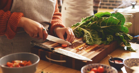 Cooking, hands and knife with person in kitchen of home for cutting or meal preparation. Food, vegetable or wood board and chef in apartment with ingredients or recipe for diet, health and nutritionの写真素材