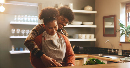 Couple, woman and cooking with romance in kitchen for meal preparation, healthy dinner and bonding together. Happy, people and helping with food recipe in home for nutrition, marriage and connectionの写真素材