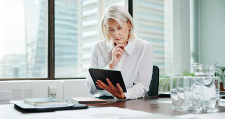 Tablet, thinking and reading with business woman in office for schedule, project vision and planning. Reflection, economy growth and investment broker with mature person in finance agency for ideaの写真素材