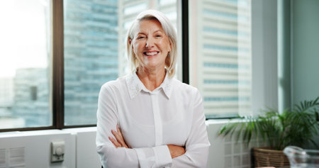 Portrait, smile and mature businesswoman with arms crossed for experience as financial advisor. Office, boss and confident professional executive, wealth consultant and asset manager in Switzerlandの写真素材