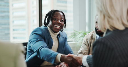 Business, man and handshake with partnership in meeting for finance deal, welcome offer and contract agreement. Financial analyst, happy and shaking hands in office for negotiation, success or hiringの写真素材