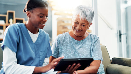 Senior woman, nursing home and tablet for healthcare, medical support and test results. Retirement, happy patient and caregiver with technology in living room for help, checkup report and insuranceの写真素材