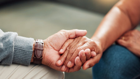 Comfort, holding hands and support with couple in living room of home together for bonding, compassion or love. Empathy, sympathy and trust with people closeup in apartment for connection or healingの写真素材