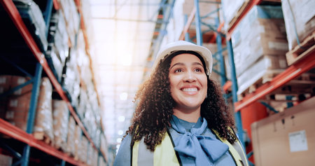 Smile, walking and logistics with woman in warehouse for shipping cargo, delivery and safety manager. Supply chain, distribution center and freight storage with person in factory for courierの写真素材