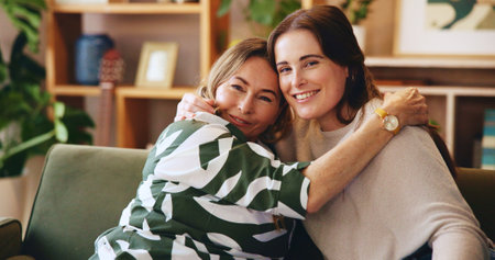 Hug, portrait and smile of mother with daughter on sofa in living room of home for bonding or love. Safety, security and visit with happy family in apartment together for relax, support or trustの写真素材