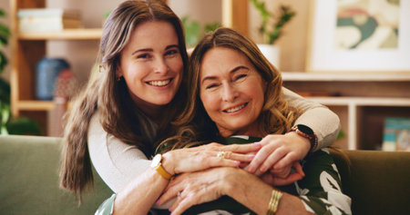 Hug, portrait or smile with mother and daughter on sofa in living room of home for bonding or trust. Love, safety and security with happy family embracing in apartment together for relax, supportの写真素材