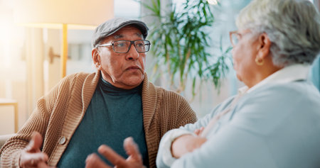 Senior couple, fighting and sofa at house for argument, divorce conflict and partner disagreement. Elderly people, communication problem and blame for separation, marriage crisis and betrayal dramaの写真素材