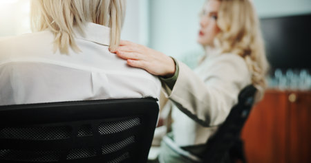 Business people, hands and empathy on shoulder in meeting for support group or counseling at office. Employees, colleagues or team talk with sympathy, trust or safe space for therapy at workplaceの写真素材