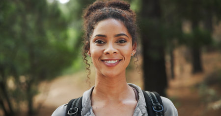 Hiking, smile and portrait of woman in nature with backpack for exercise, workout and walking. Fitness, travel and happy person in forest, trail and woods for trekking, adventure and explore outdoorの写真素材