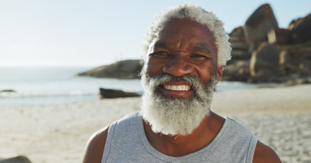 Beach, senior black man and travel in portrait for holiday, peace and happiness with confidence. Ocean, male person and outdoor with smile for adventure, vacation and tourist for exploration in seaの写真素材