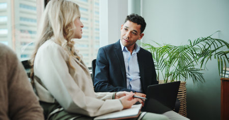 Meeting, notebook or business people in discussion for teamwork, strategy or partnership. Laptop, smile or advisor in office talking for feedback review, documents or project briefing for planningの写真素材