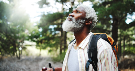 Hiking, thinking and senior man with fitness, travel and thoughtful with reflection. African person, outdoor and hiker with weekend break, nature and countryside with wellness, healthy and exploreの写真素材