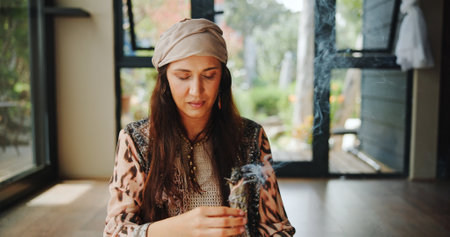 Sacred, woman and sage with smoke, prayer and burning herb for purification and indigenous tradition. Chakra, spiritual and person with Salvia apiana for ritual, morning and smudging for inner peaceの写真素材