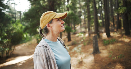 Hiking, thinking and woman with fitness, travel and thoughtful with reflection. Mature person, outdoor and healthy hiker with weekend break, nature and countryside with wellness, journey and exploreの写真素材