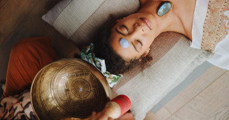 Healing, calm and woman with healer, hands or mantra for inner peace, spiritual or gemstone for chakra. Meditation, shaman or sound therapy with Tibetan singing bowl, vibration or holistic for personの写真素材