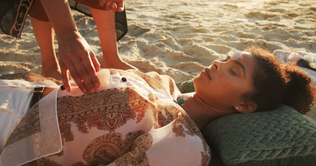 Woman, crystal and healing at beach with chakra balance, care and therapy with rest on vacation. Person, stone and helping hand with mineral, mindfulness and peace with zen on ground in summerの写真素材
